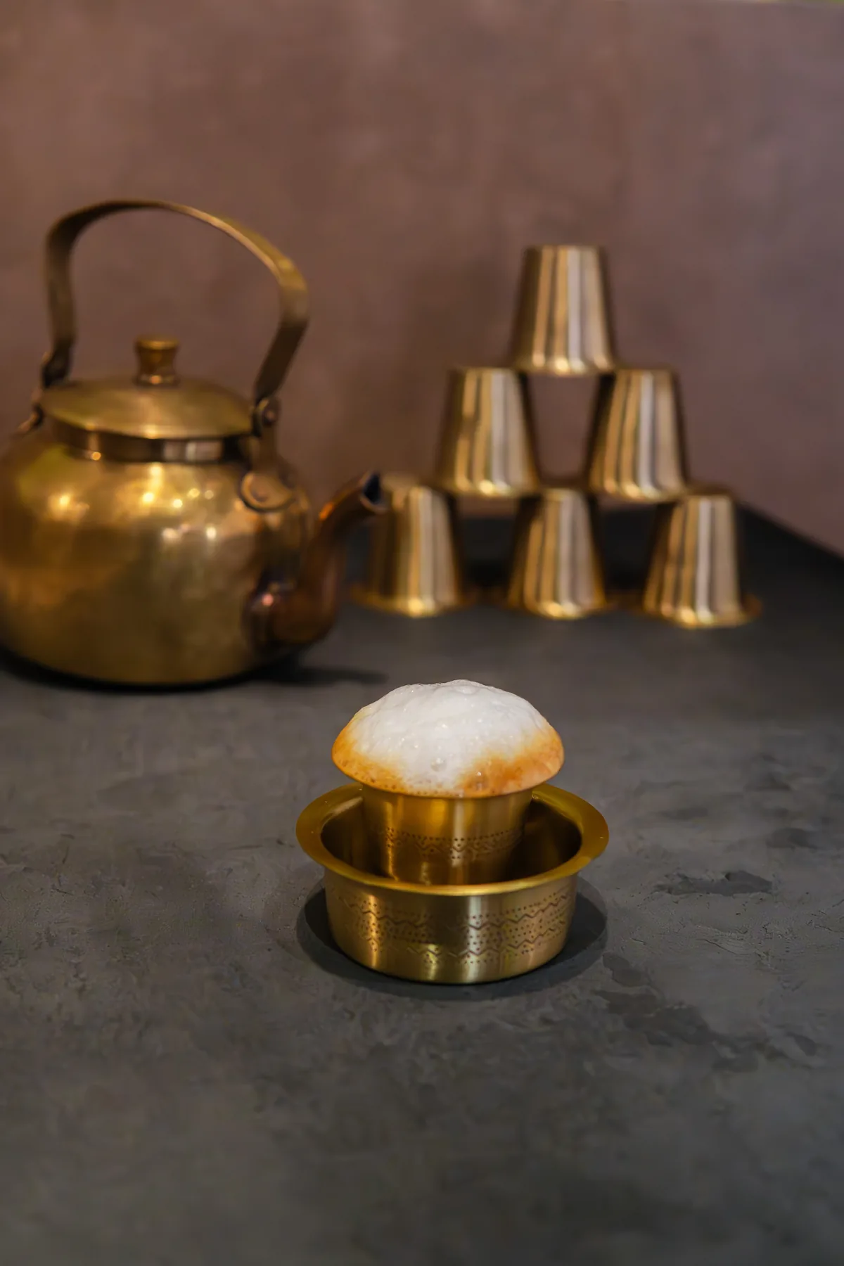Frothy South Indian filter coffee in a brass tumbler and davara
